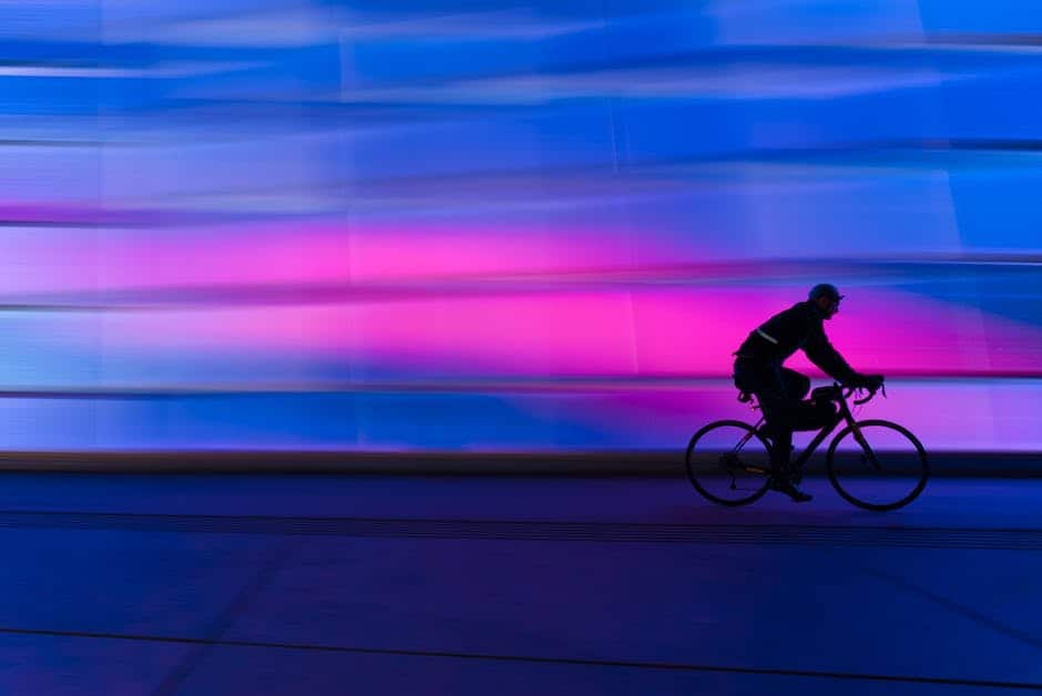 A person riding a bicycle in front of a colorful building.