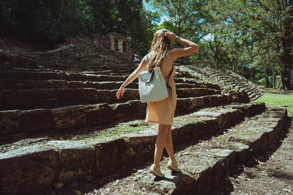 A woman walking down a set of steps in the jungle.