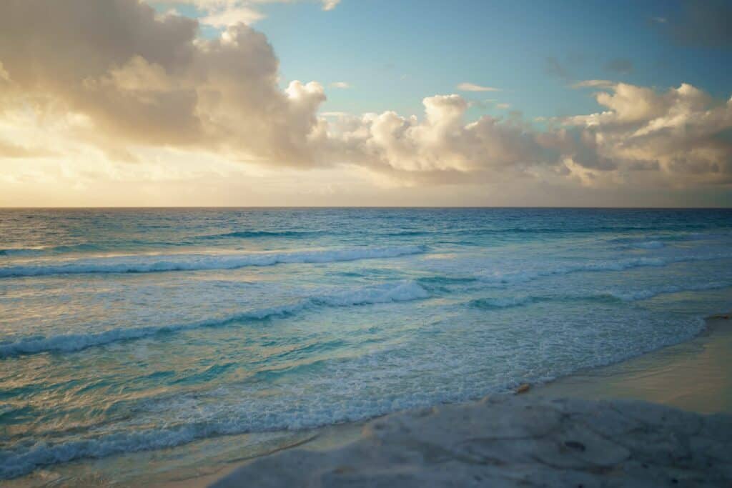 A beach with waves and clouds in the background at Cancun in January.