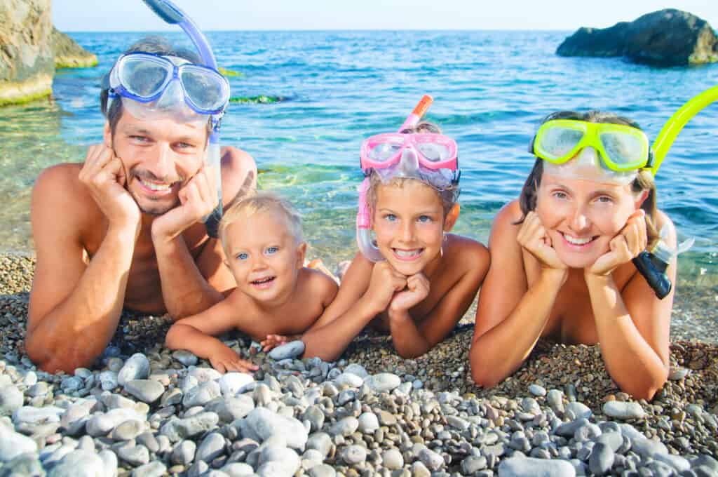 A family enjoying snorkeling activities on the beach in Cancun.