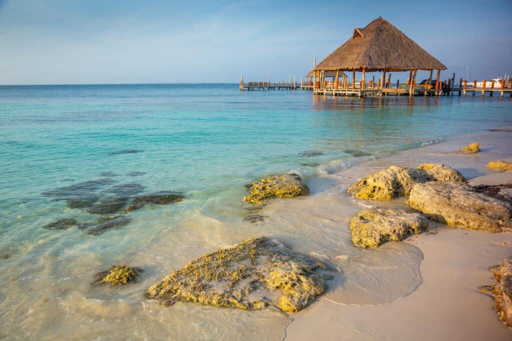 A rocky beach with a hut, suitable for March weather in Cancun.