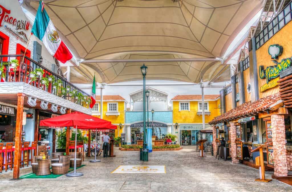 A shopping mall with a lot of tables and chairs.