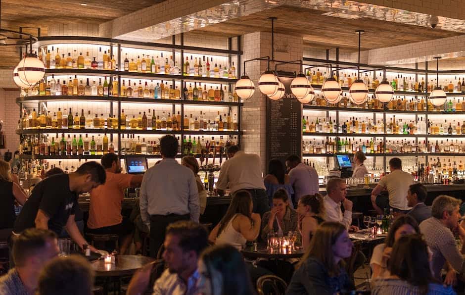 A crowd of people sitting at tables in a bar.