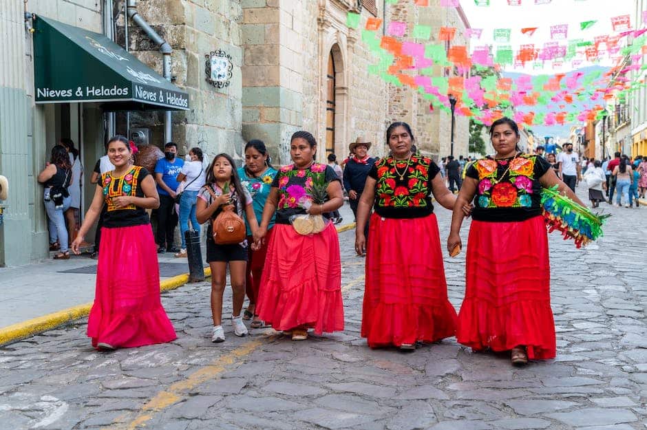 A group of women in colorful dresses walking down a cobblestone street.