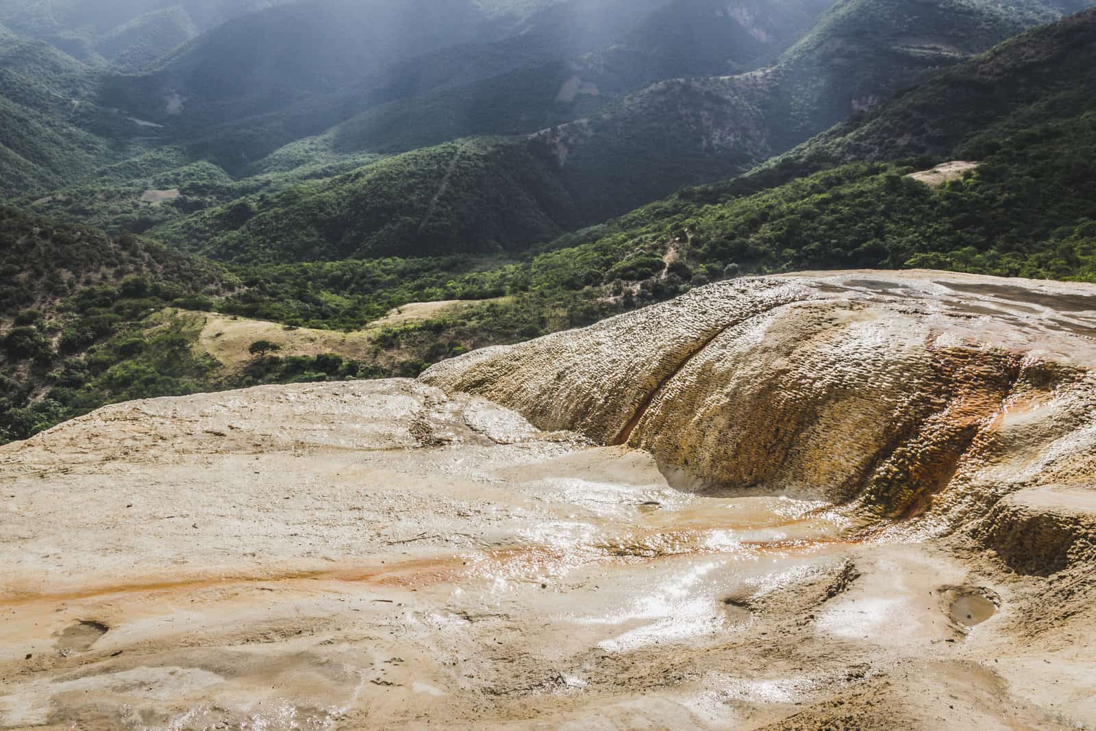 A waterfall in a rocky area surrounded by mountains in Oaxaca.