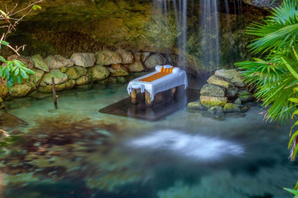 A waterfall with a massage table in the middle of it.