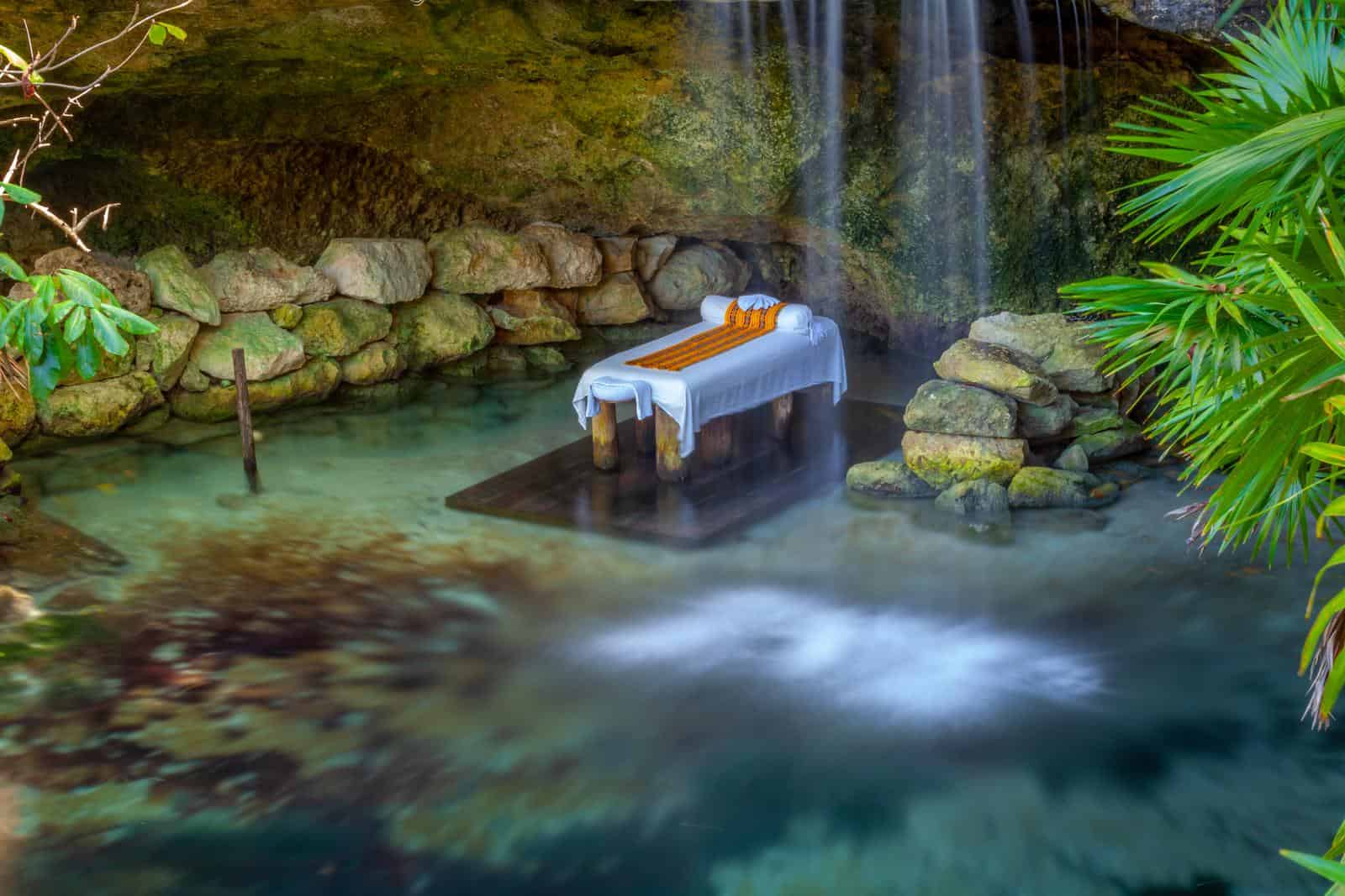 A waterfall with a massage table in the middle of it.