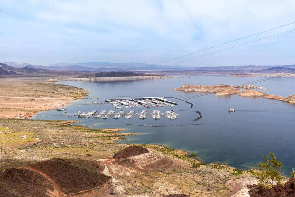 A boat docked in a lake with mountains in the background.